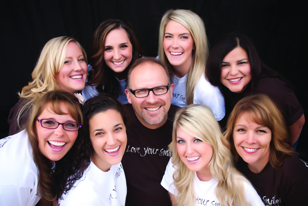 The friendly office staff smiling with Roseville CA dentist Matt Comfort.